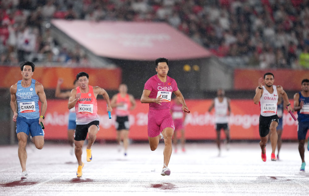 9月28日,中国队选手谢震业(中)在爱知·名古屋亚运会田径项目男子4X100米接力决赛中。新华社发(吕小炜摄)