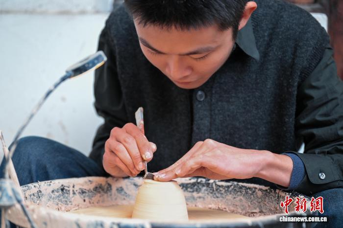 1月29日，台湾青年张昀澂正在为茶友制作陶瓷茶杯作为马年新春礼物。中新社记者 刘忠俊 摄