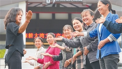 村民周秀凤(右二)正和村里的姐妹们接受礼仪培训,她们即将成为村里一家新民宿的服务员。村民们就近上班,挣钱顾家两不误。