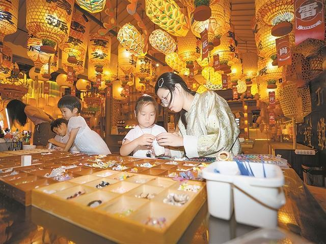 小朋友在工作人员的引导下体验制作非遗油纸灯笼。（本报记者 卢剑豪 摄）