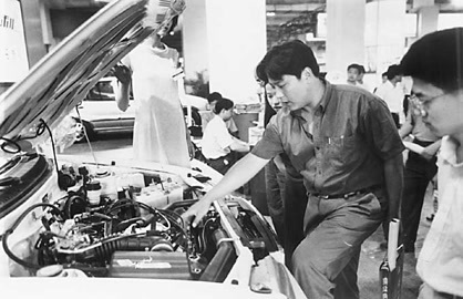 1999年，在北京国际汽车、零部件及相关产品展览会上，参观者对夏利电喷发动机很感兴趣。 李继辉摄