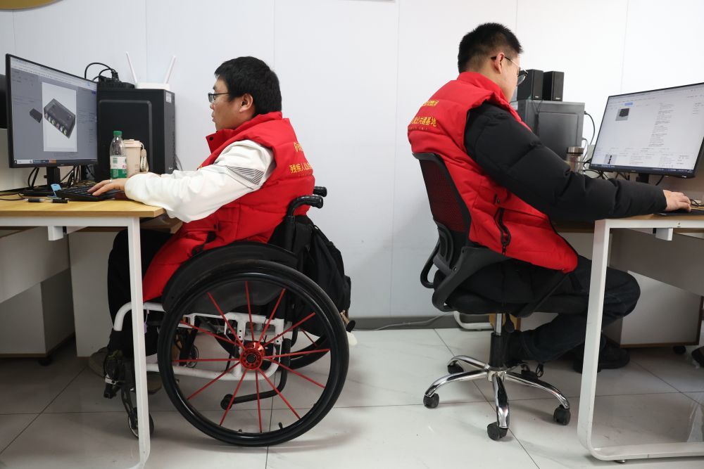 2026年1月14日，在甘肃省兰州市心连心社会工作服务中心残疾人就业工坊，人工智能（AI）训练师李为明（左）进行数据标注工作。甘肃省残联与兰州市心连心社会工作服务中心联合高校共同举办面向残疾人的AI训练师数据标注培训班，首批来自甘肃各地的残疾人学员中，19人最终通过了人社部门承认的职业等级认定考试，获得了相应等级证书。不少学员已与企业签订就业协议持证上岗，开始从事数据标注工作。