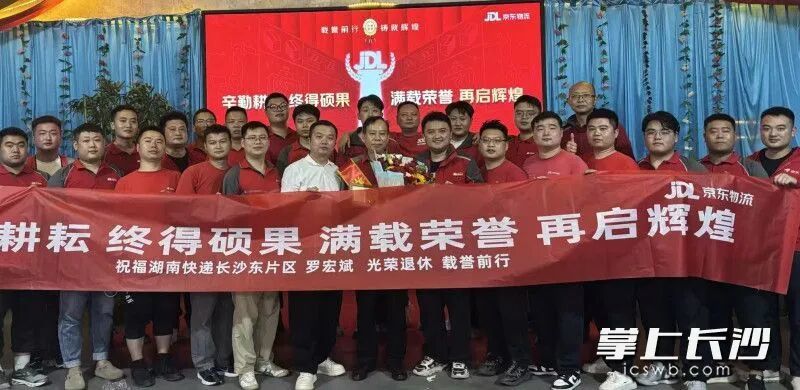 在京东物流长沙北辰站点，年轻快递小哥们簇拥着罗宏斌，为他送上鲜花与祝福。