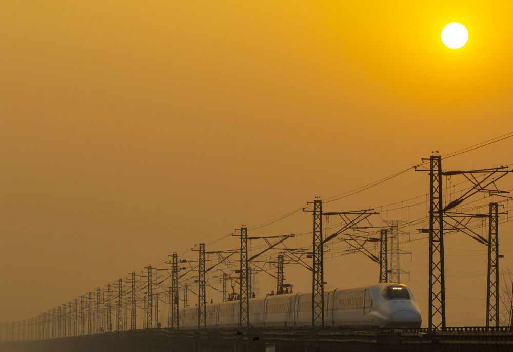 ↑ 1月25日,列车行驶在江苏省泰州市海陵区境内(无人机照片)。新华社发(汤德宏 摄)