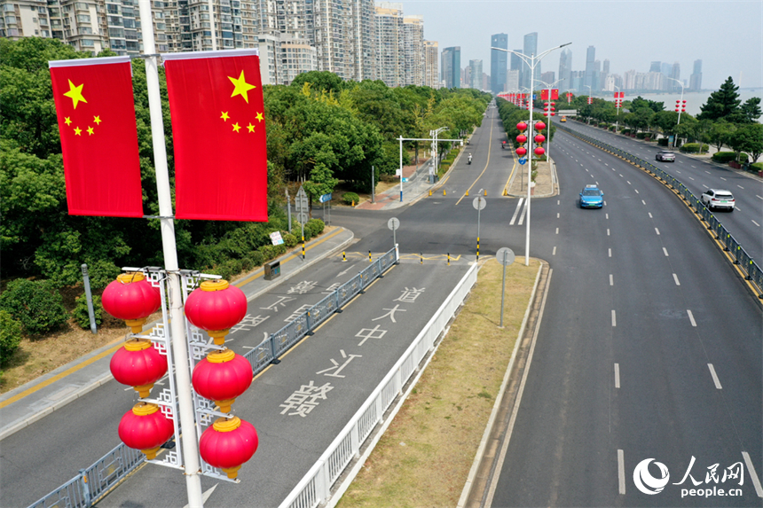 南昌市红谷滩区的道路两侧悬挂着崭新的国旗，城市洋溢着喜庆祥和的节日氛围。人民网记者 时雨摄