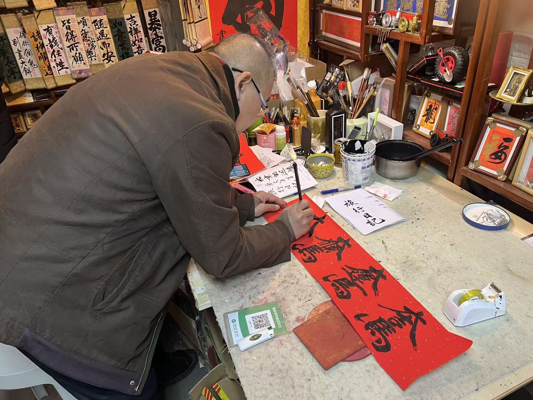 王建宇伏在案头,正在设计马年春联的横批