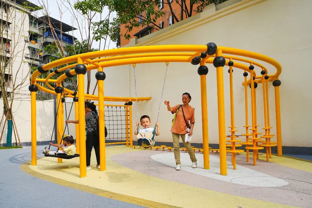 2026年10月8日,在重庆市北碚区天生街道吾悦广场片区,家长带着孩子在改造后的微型儿童游乐场内玩耍。 (1).jpg