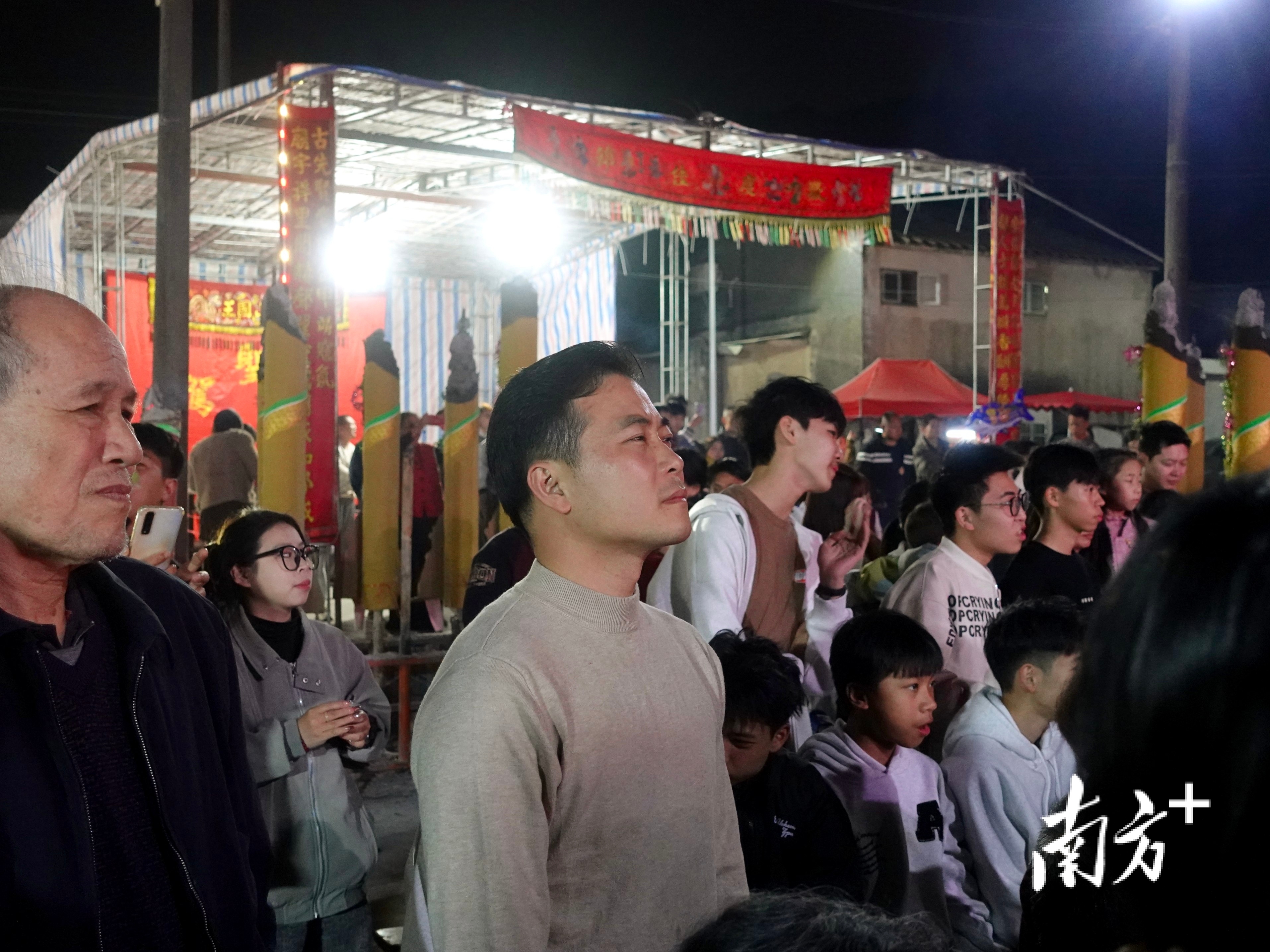 西都村党支部书记卢浩凯站在人群中默默观看演出,他是村里最早一批返乡办“村晚”的大学生。