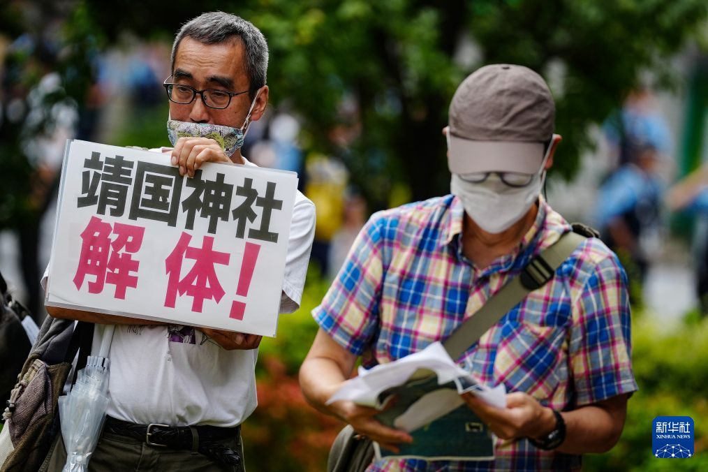 8月15日，在日本东京的淡路公园内，日本民众手持标语参加集会。新华社记者 贾浩成 摄