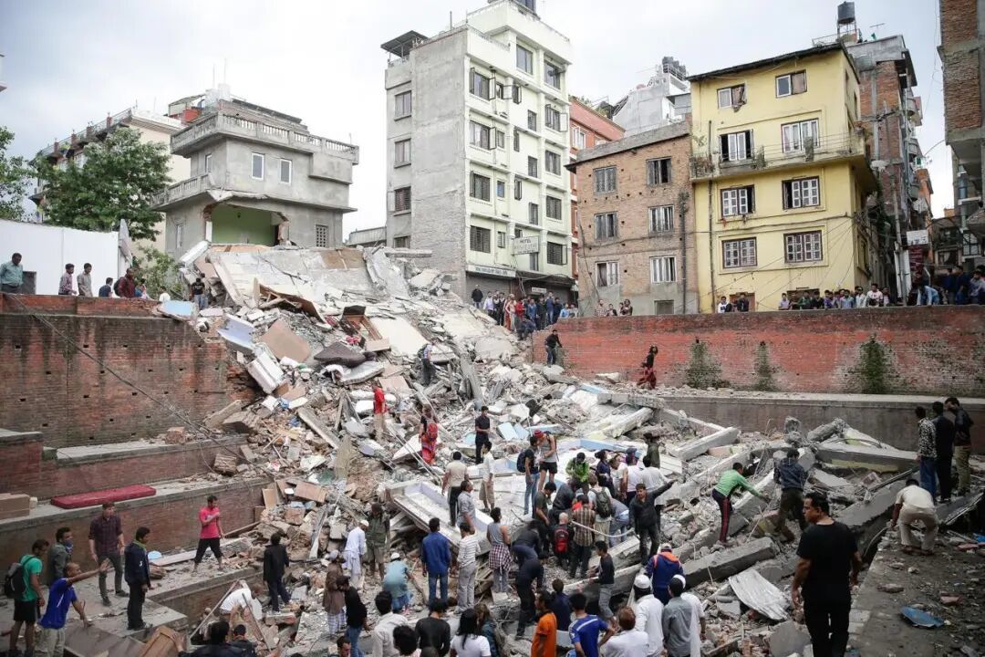 2015年4月，地震过后，加德满都居民在建筑废墟中寻找幸存者。（图源：美联社）