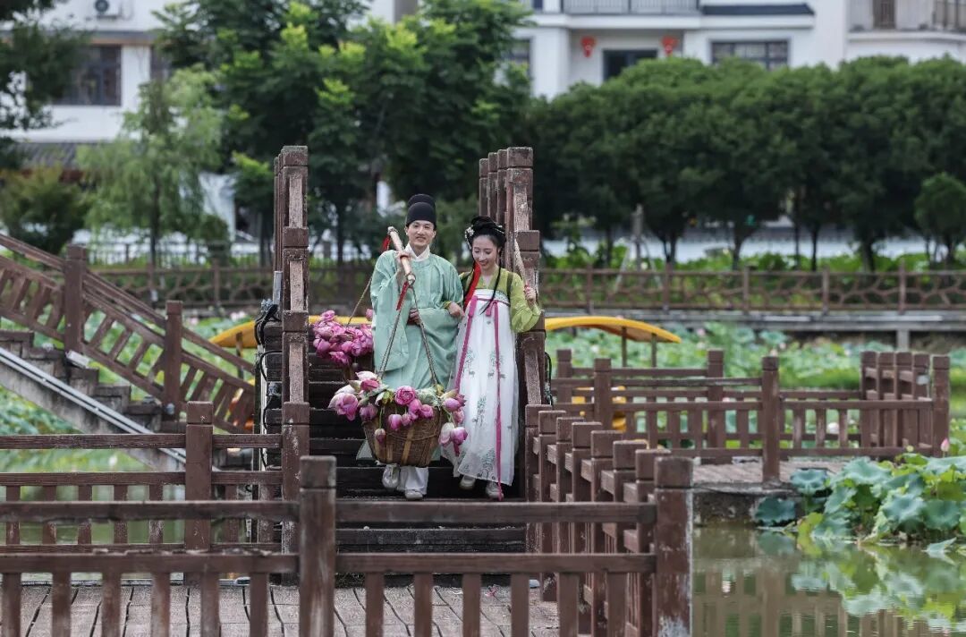 演员在建德市大慈岩镇的十里荷花景区展现荷花郎叫卖莲子和荷花的场景, 新华社记者 徐昱