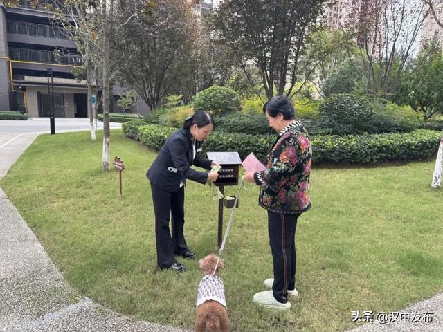 ▲汉台区雅居乐小区物业管家指导居民使用免费拾便袋。 记者 李佩蓉 摄