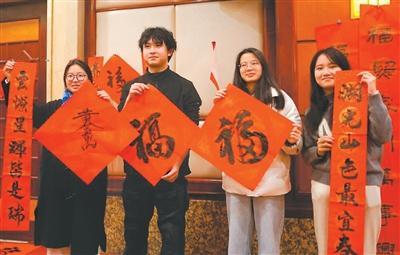 图为在福州举办的台胞迎新春联谊活动中,台胞展示书写的“福”字和春联。