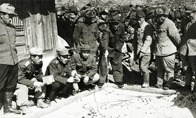 1952年，向守志（中间执棍者）组织团以上干部进行沙盘作业。