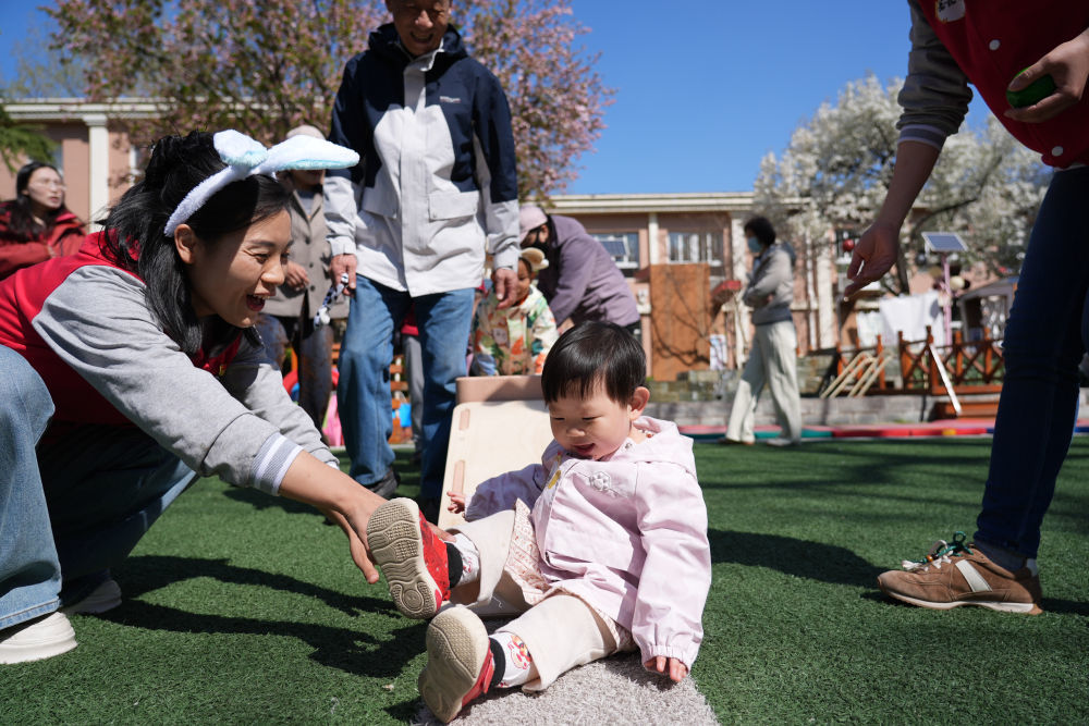 4月1日,在北京市第五幼儿园亲子托育活动现场,家长和孩子在老师引导下参加户外活动。新华社记者 谢晗 摄