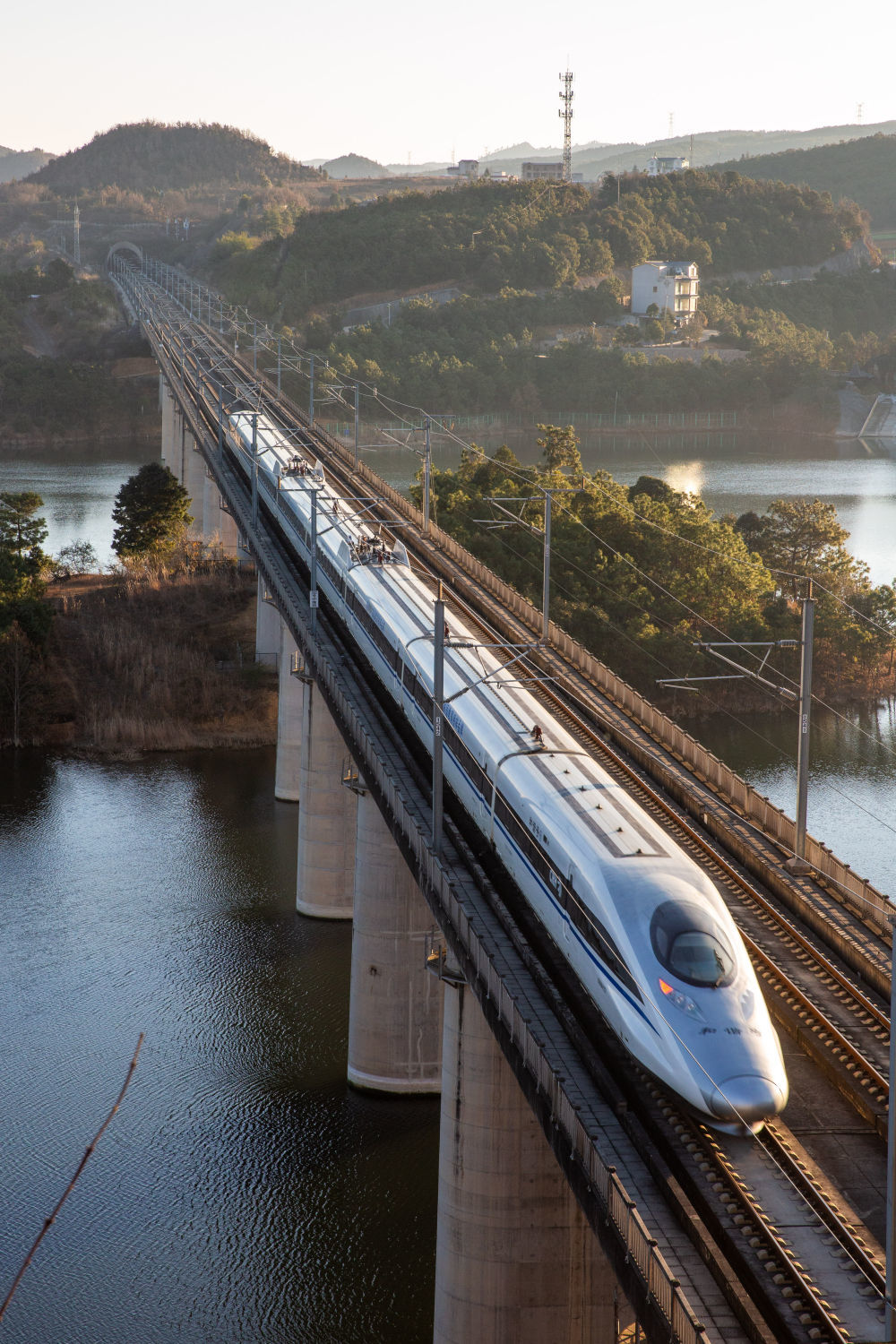 ↑ 1月25日,动车组列车从云南省曲靖市马龙区旧县街道车马碧水库上驶过。新华社发(杨俊鹏 摄)