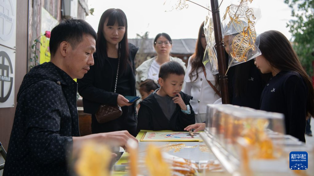 10月3日,游客在河南新郑东门东里创意街区购买糖人。新华社发(孔维钾摄)