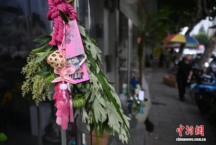 6月16日，浙江凤起花鸟市场花店外悬挂的“艾草花束”吸引市民。　中新社记者 王刚 摄
