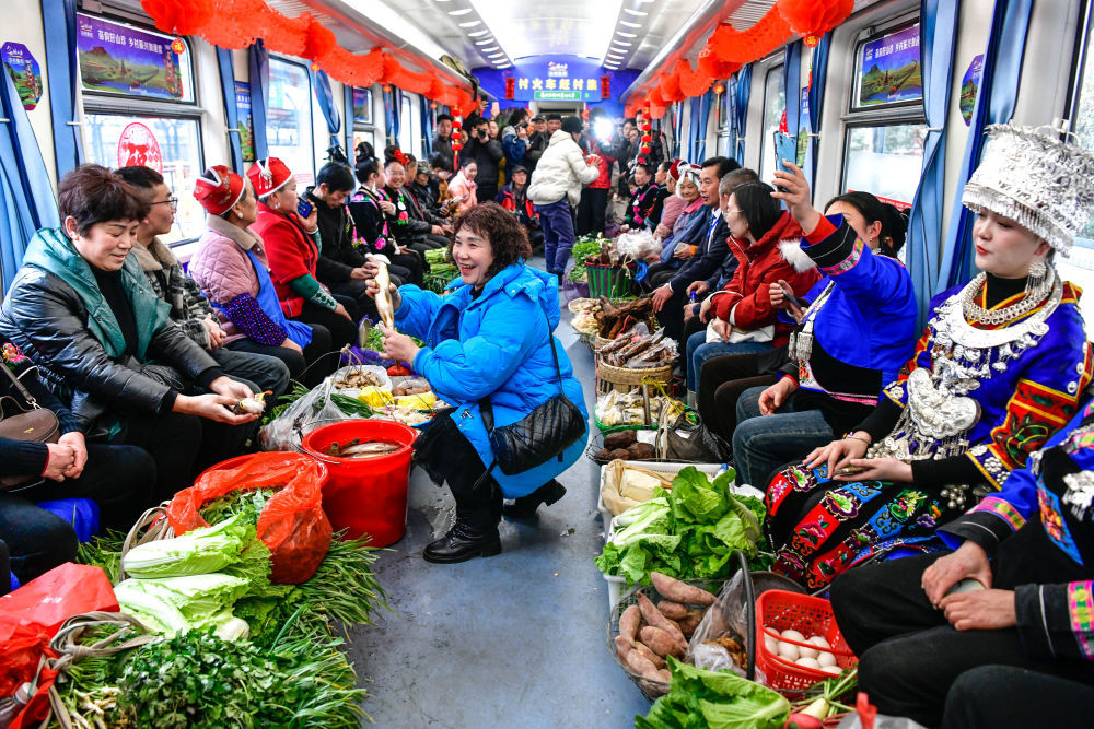 2025年1月18日，乘客在贵阳开往玉屏的5640次“慢火车”上选购稻花鱼。往返于贵阳与玉屏之间的5640/39次列车，是一趟穿行于贵州少数民族地区、逢站必停的“移动集市”。自1997年开行至今，为沿途10多个小站附近的少数民族村寨村民提供了便宜、便利、快捷的出行方式。 新华社记者杨文斌摄