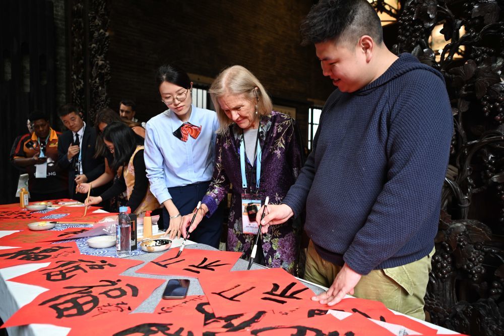 2月6日，亚太经济合作组织（APEC）2026年第一次高官会及相关会议的部分与会代表在广州陈家祠体验中国书法。 新华社记者 邓华 摄