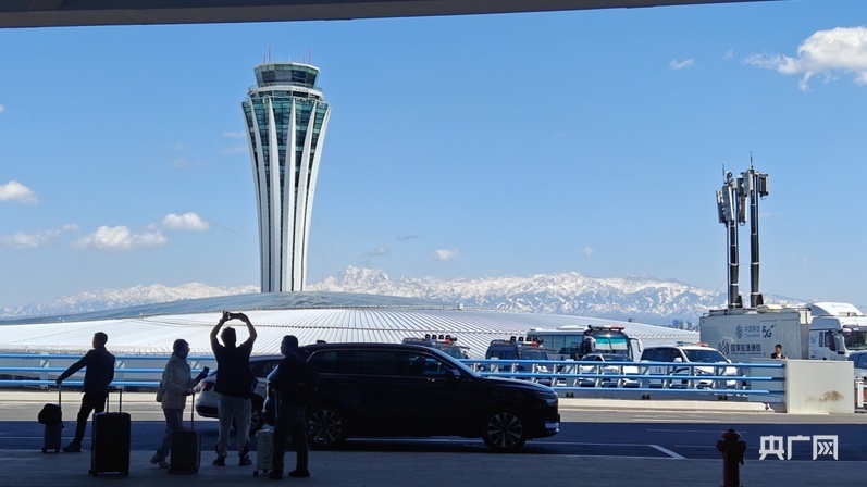 旅客在北航站区新航站楼前拍照留念 （央广网记者 郭璁悦 摄）