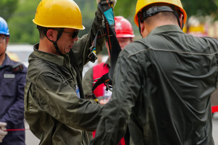 在河南南阳邓州市,国网南阳供电公司工作人员在完成高空带电作业后,棉质工作服已经被汗水湿透。(受访者供图)