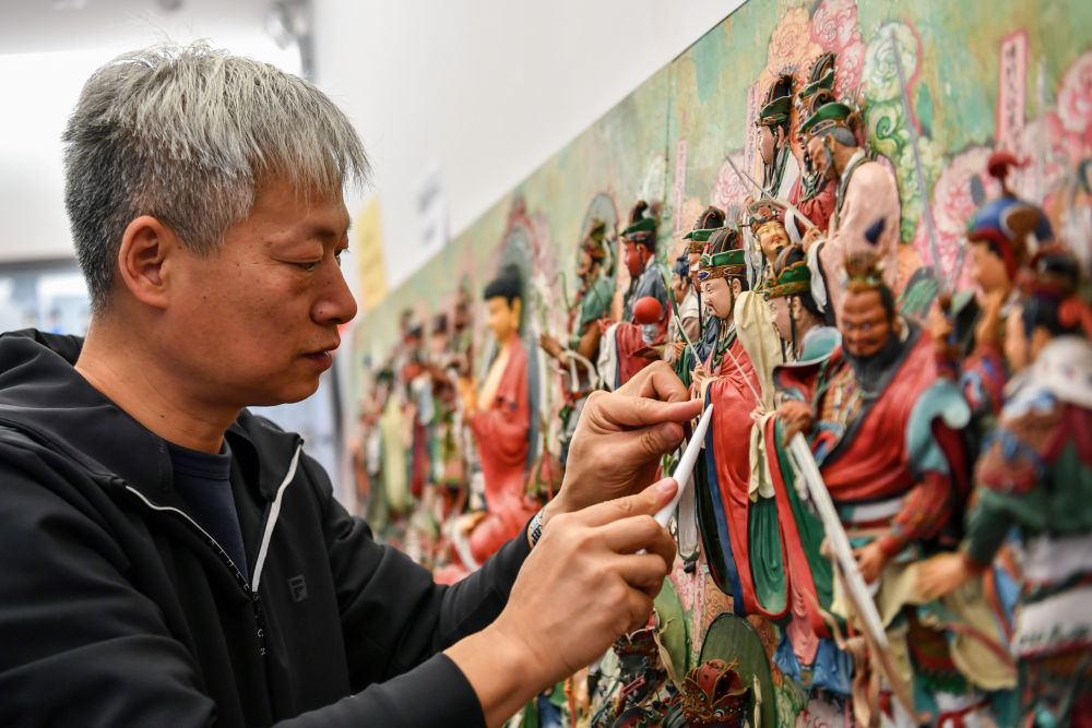 在忻州古城，面塑技艺非遗传承人卢佩宏在制作面塑。新华社记者 曹阳 摄