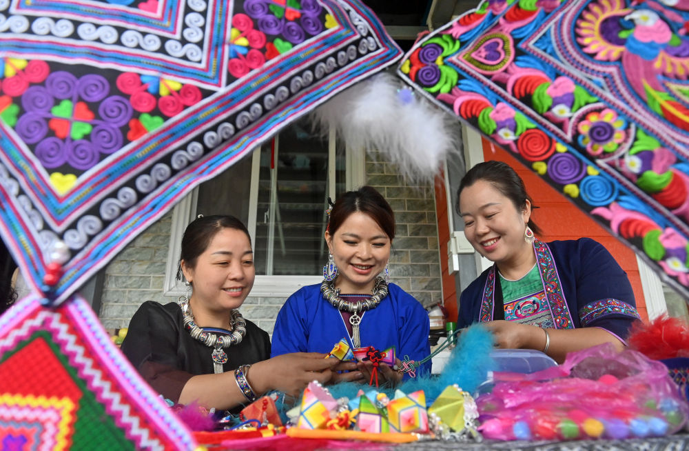 侗族吉祥花是广西三江侗族自治县的传统手工艺品，融侗族印染、刺绣、织锦等技艺于一体，是极具民族特色的吉祥饰品。近年来，当地积极研发吉祥花主题文旅产品，销售规模不断扩大。这是三江县八江镇三团村村民在探讨侗族吉祥花制作技艺（2025年9月24日摄）。