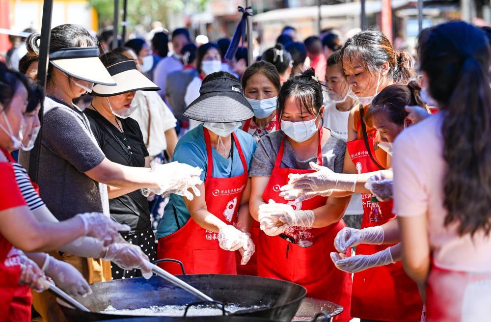 7月19日,志愿者在重庆彭水县山体崩塌救援现场附近的一处“爱心食堂”做午餐。