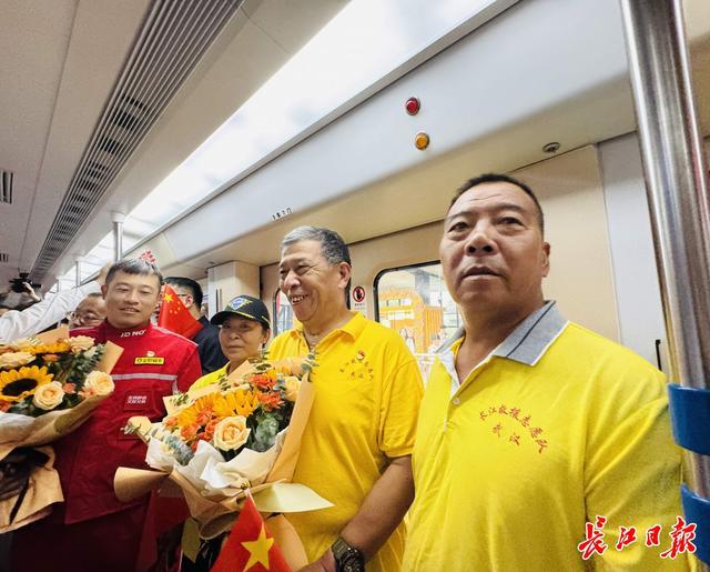 焦浩（左一）、张建民（左二）乘坐“英雄武汉”号地铁专列。 记者陶常宁 摄
