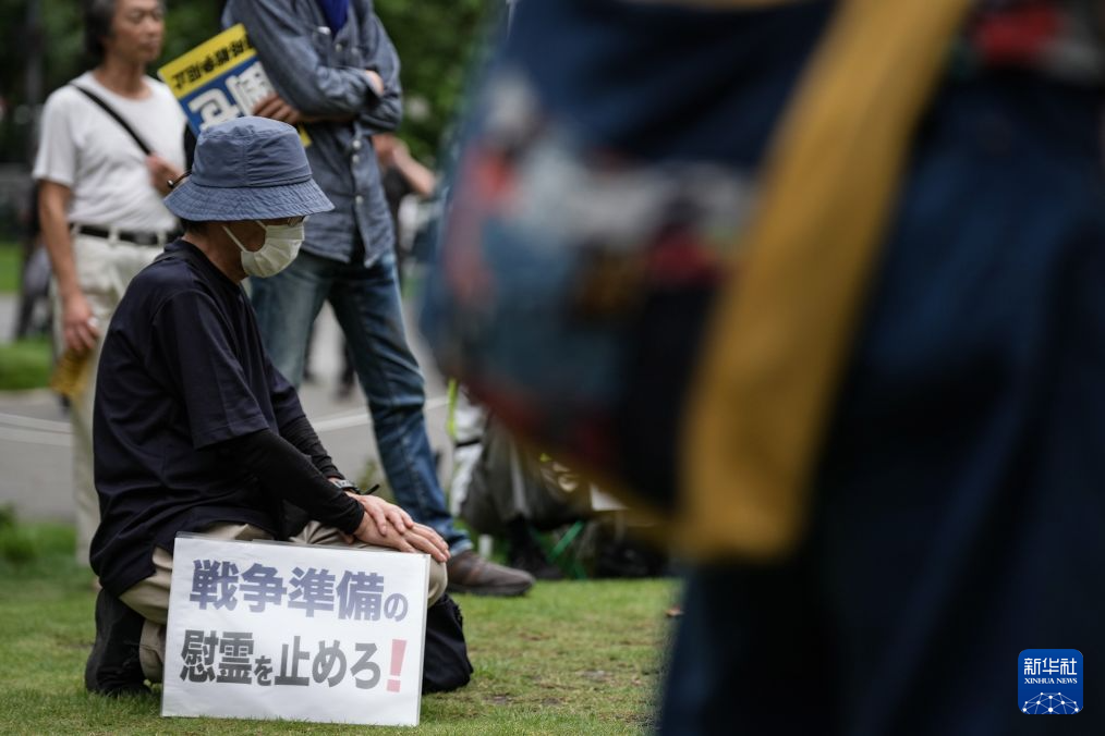 8月15日，在日本东京的淡路公园内，日本民众手持标语参加集会。新华社记者 贾浩成 摄