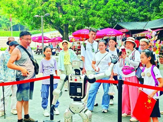 游客在罗浮山景区与机器人互动。惠州日报记者卢泓宇 摄