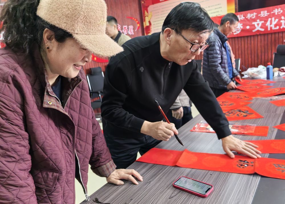 来自梨树县文联、县书法家协会的书法志愿者,现场挥毫泼墨,为村民送上春联和福字。新华社记者 宗巍 摄