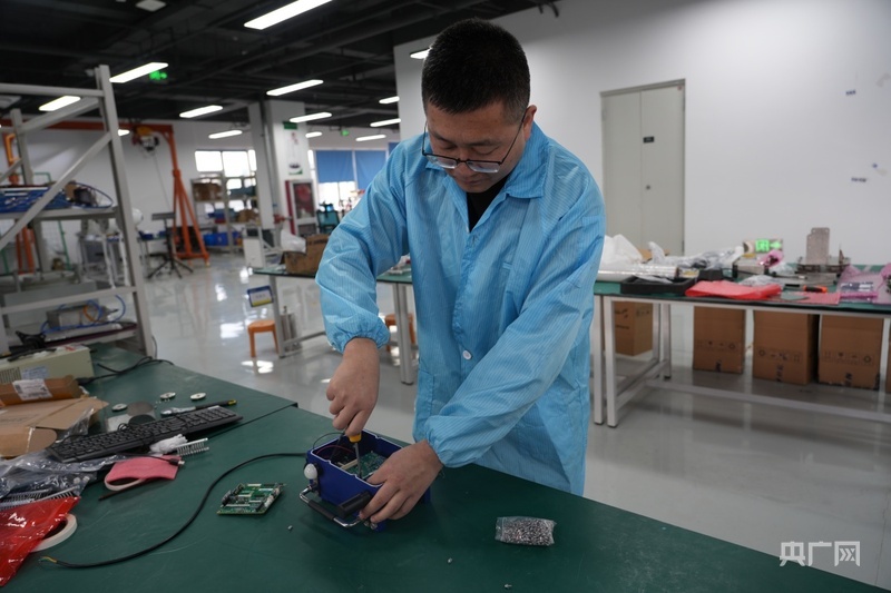 工作人员正在组装零部件（央广网记者 周思杨 摄）