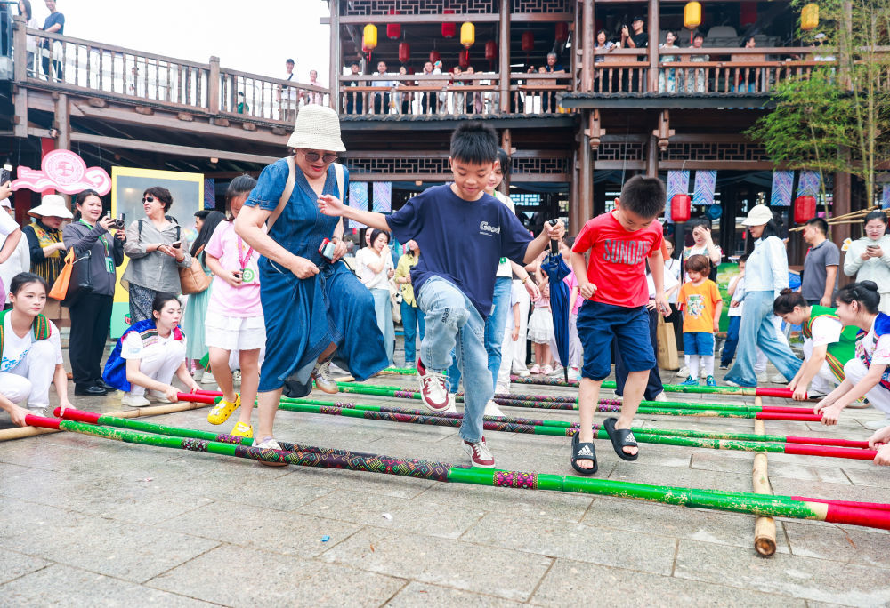 这是市民和游客在2026年“广西三月三&middot;八桂嘉年华”文化旅游品牌活动开幕式上共跳竹竿舞。