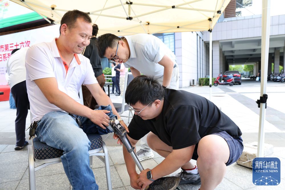 ↑ 5月16日，工作人员在江苏省如皋市助残日活动上对假肢进行维修保养。新华社发（许丛军摄）