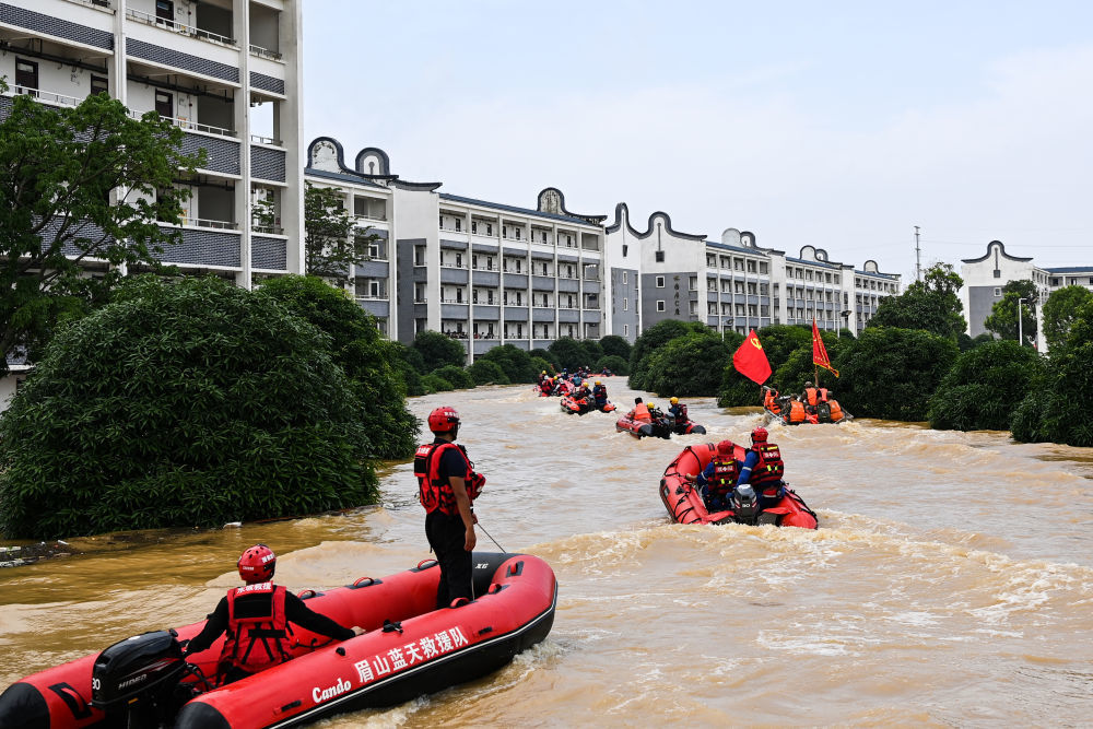 ↑ 7月9日,在广西贵港市西江教育园区,大批救援人员乘坐橡皮艇去转运受困学生。新华社记者 曹祎铭 摄