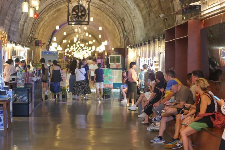 8月10日，在重庆市两江新区地下之城火锅店，游客在防空洞内排队等候餐位。新华社记者 黄伟 摄