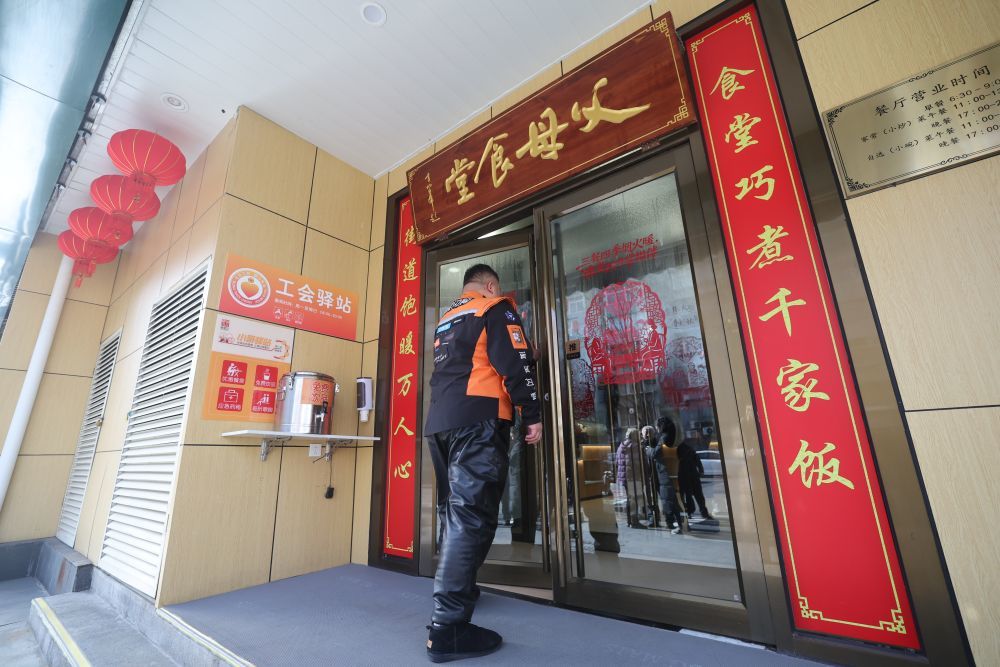 2月10日，一名快递员走进新街口街道父母食堂。