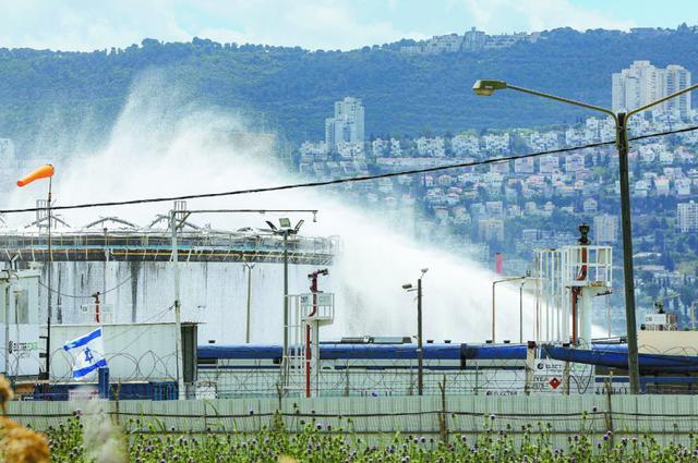 据以色列第12频道电视台30日报道，以北部城市海法的炼油厂当天在导弹袭击中起火。图为消防员正在灭火。 （视觉中国）