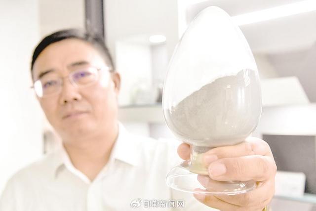 郭建功向记者展示新型先进建筑材料的细腻粉质。 邯郸新闻传媒中心记者 李磊 摄