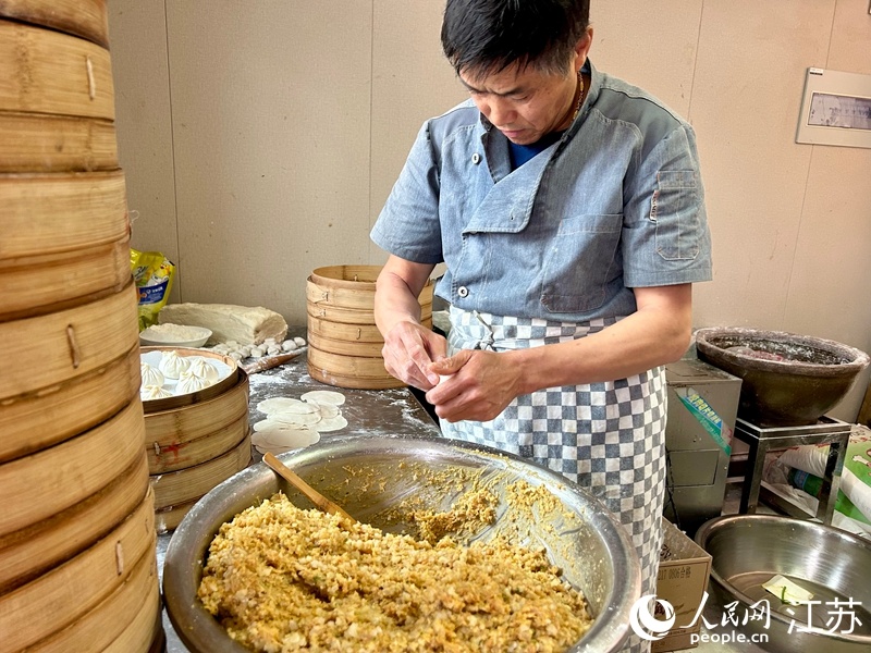 一位厨师正在制作龙袍蟹黄汤包。人民网记者 王丹丹摄