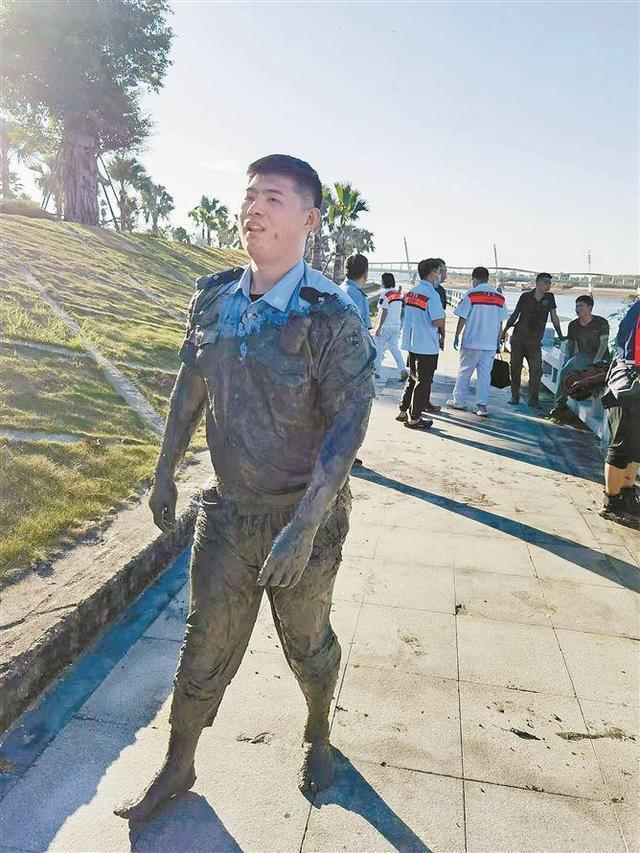 陈儒珺在滩涂泥潭爬行，救援落水受困人员。图为上岸后，他浑身是泥。