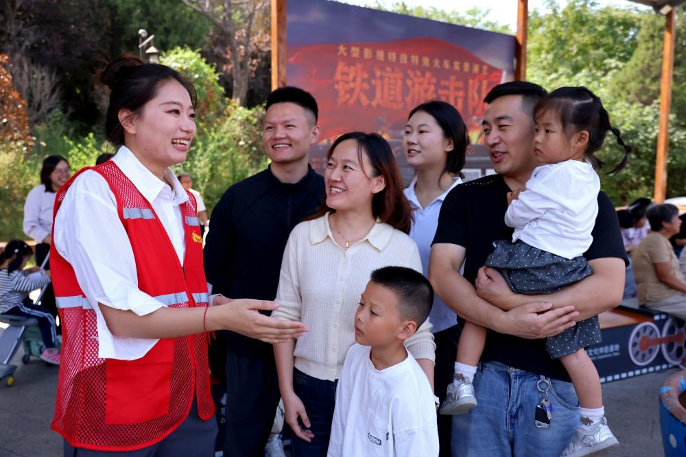10月2日,在山东省枣庄铁道游击队景区,工作人员(左一)为游客提供咨询服务。新华社发(孙中喆 摄)