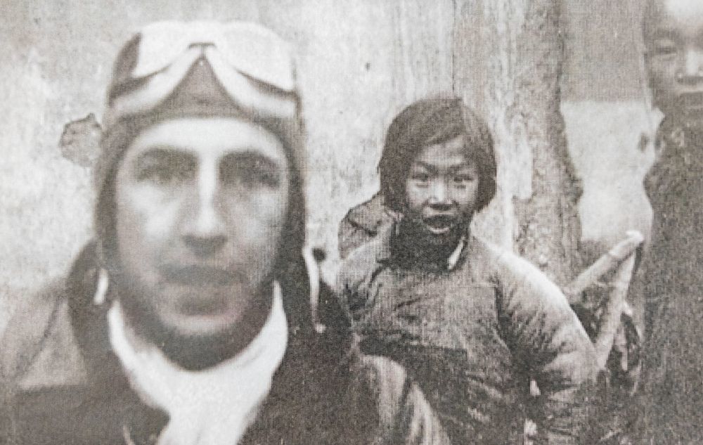 这是1942年4月,在江西上饶市广丰区,9岁的小女孩官冬香(中)站在美国飞行员身后。