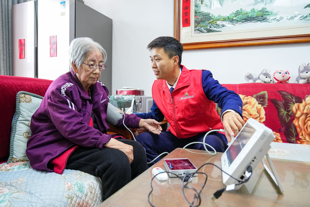 2025年10月23日，养老服务员在山东省淄博市张店区马尚街道金石社区上门开展每日健康监护服务，相关数据可同步到老人亲属手机上。新华社记者 朱峥 摄