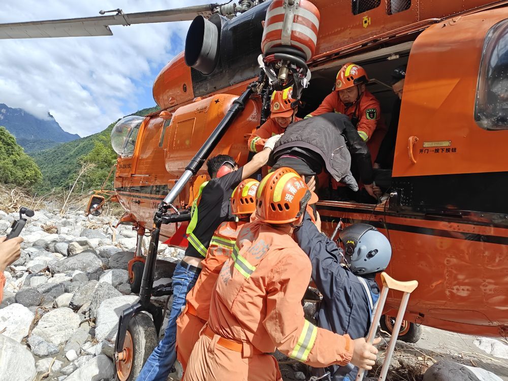 在石门县壶瓶山镇天坪村,消防救援人员将村民抬上应急救援直升机进行转移。(常德市消防救援支队供图)
