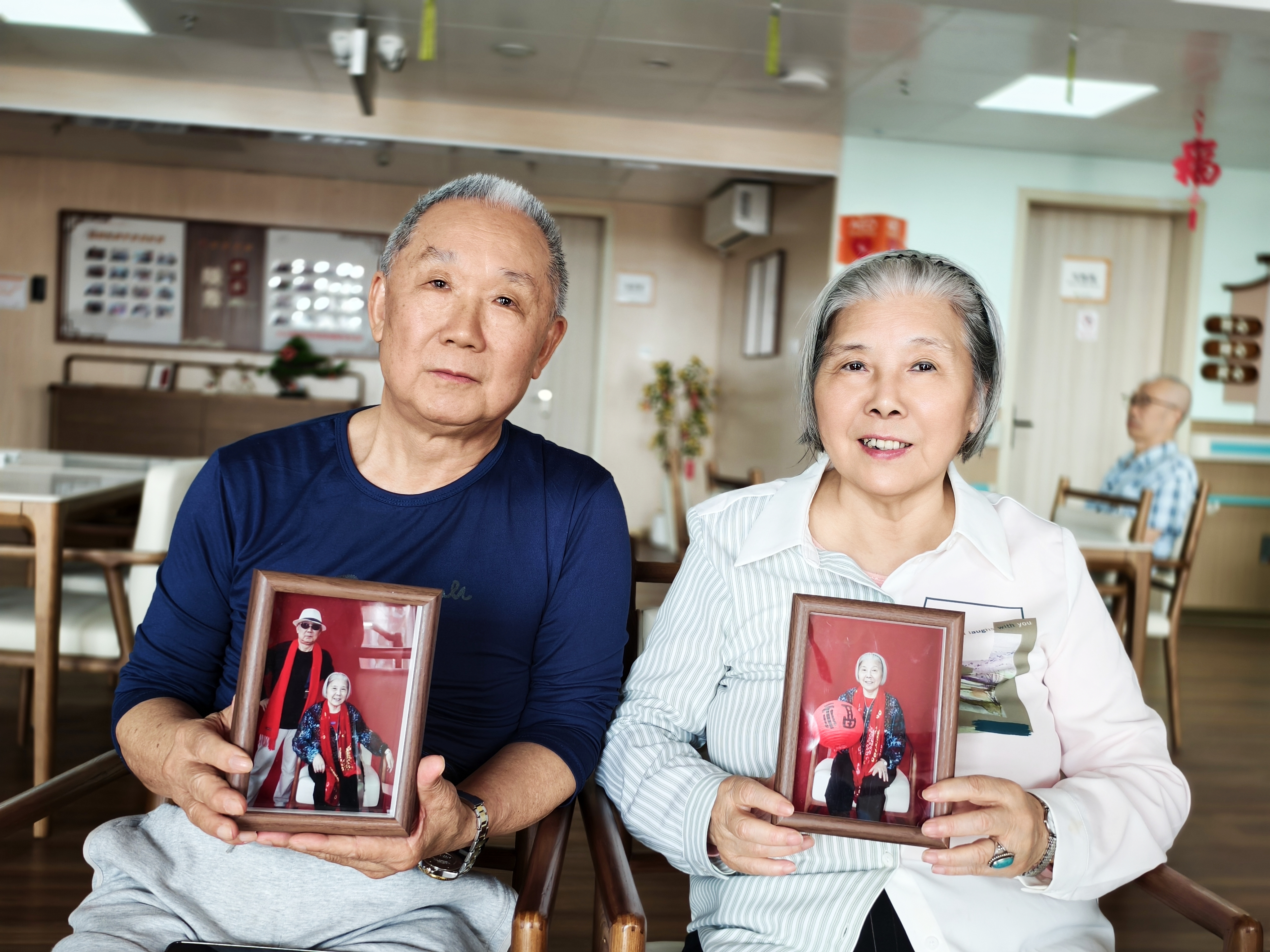 2月21日，普亲养老&middot;海口海甸岛院里，史继平、林雪珍夫妇与自己的照片“合照”。海南日报全媒体记者陈明艳 摄