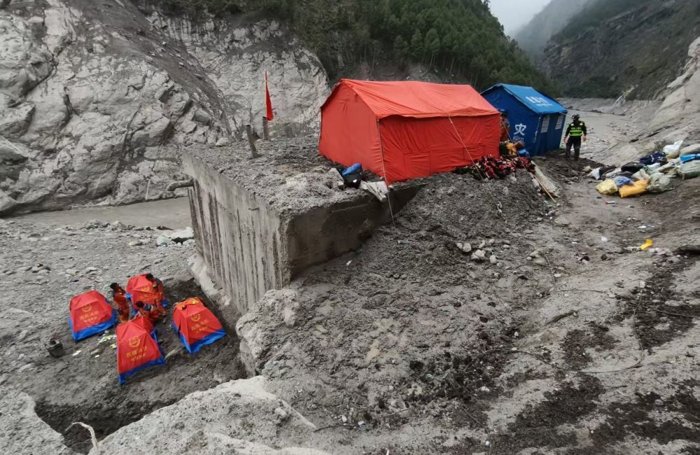 8月31日,救援人员在蓄水池旁和顶盖上搭建帐篷。