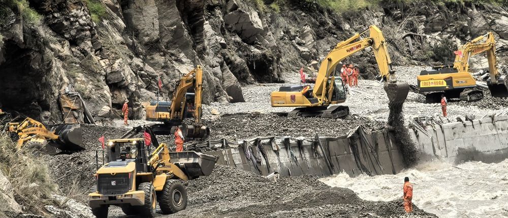 8月27日,救援车辆在为通往灾区的道路清淤。截至8月27日18时,受灾路段已抢通800米左右。新华社发